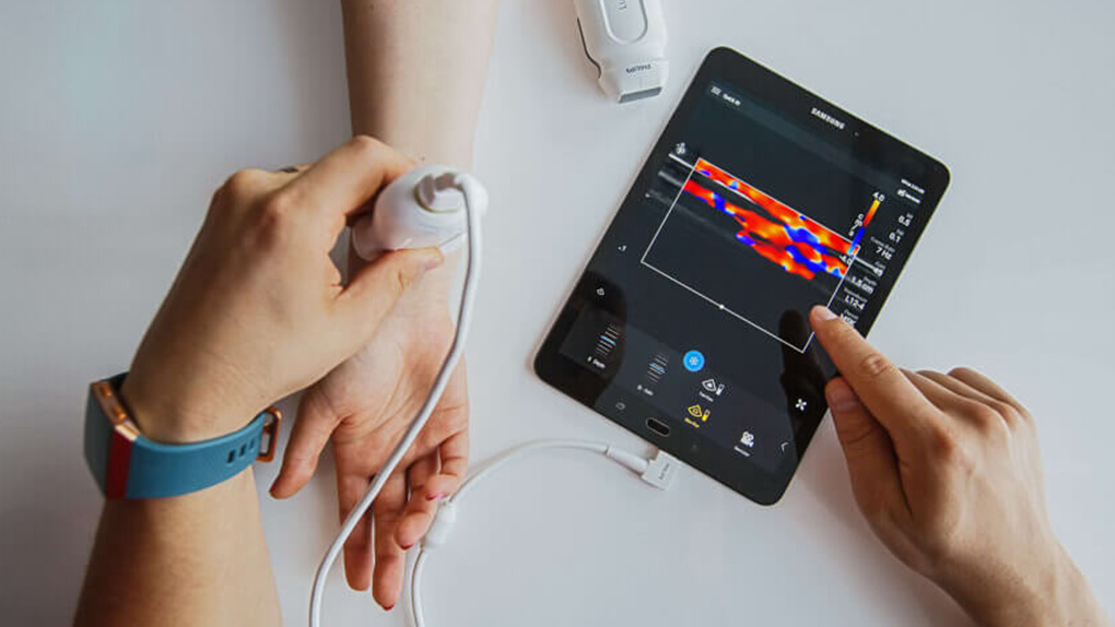 Doctor scanning a patient for diabetes with a tablet running an application